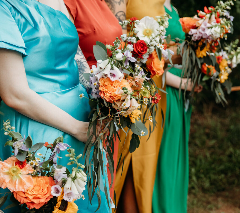 Close up photo of bridesmaids' bouquets of multicolored flowers