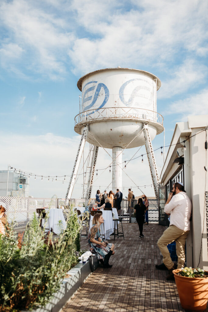 Iconic water tower overlooking a rooftop wedding venue with guests enjoying an evening in Oklahoma City